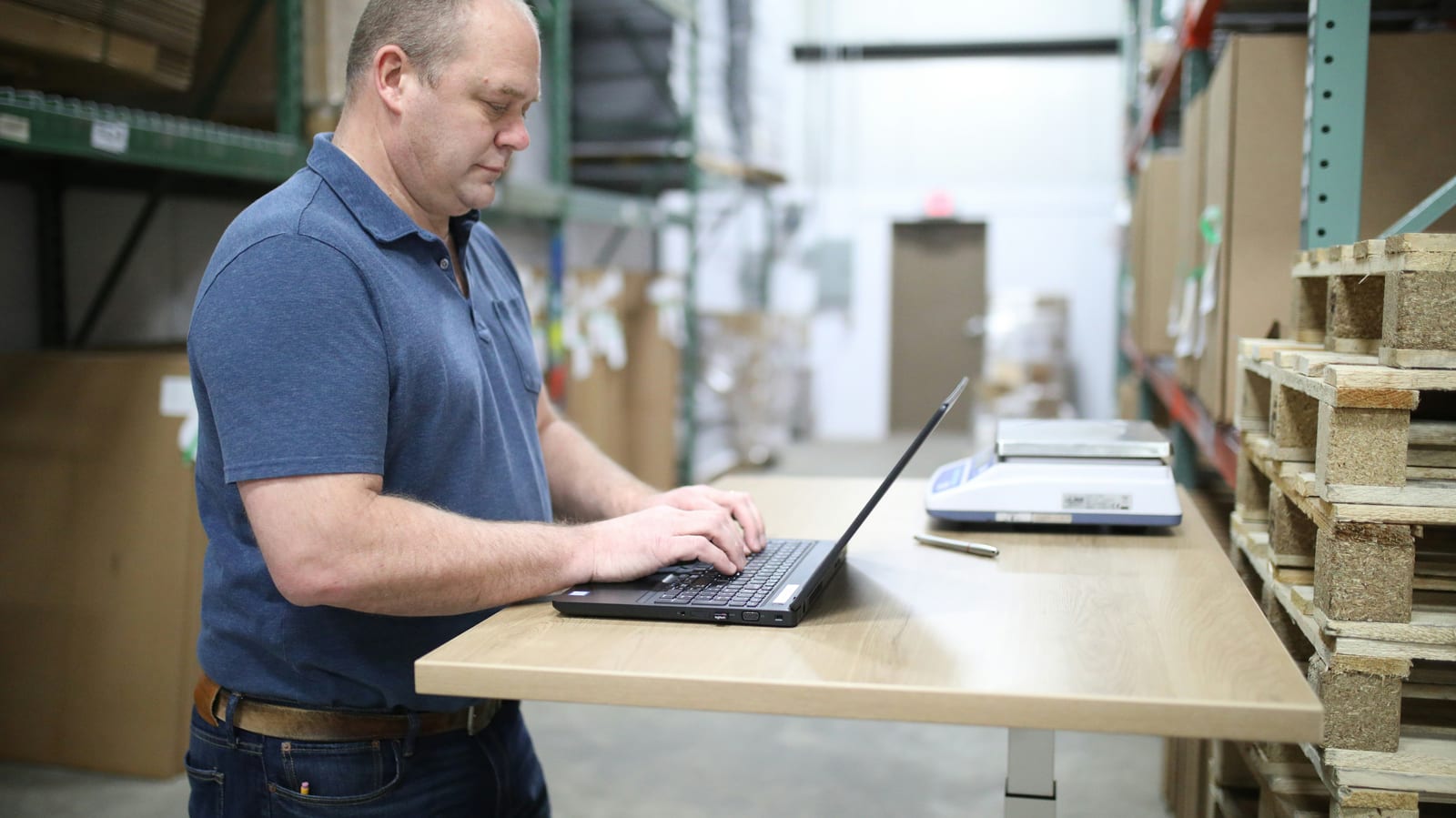 A store owner replying to customers at a laptop